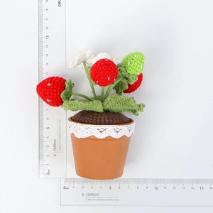 Detailweergave van handgehaakte aardbeienplant in pot van 12 cm hoog met liniaal