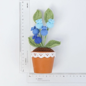Gedetailleerd beeld van handgehaakte bosbessenplant in pot met maatstaf voor afmeting