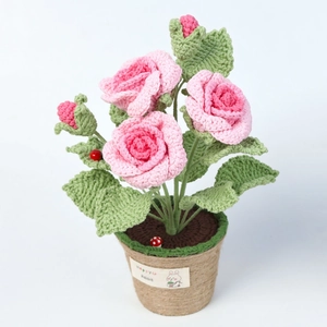 Gros plan de roses au crochet faites main avec fleurs en laine rose et coccinelle