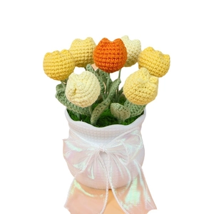 Handgefertigte gehäkelte Tulpen im Topf mit gelben und orangefarbenen Garnblumen als Deko