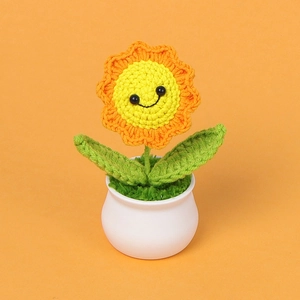 Handmade crochet sunflower plant in white pot with a cute black smiley face design