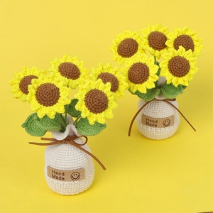 Detail of two handmade crochet sunflowers in white pots with Hand Made leather labels