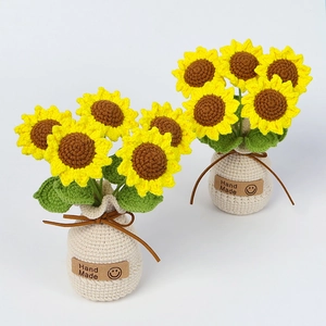 Close-up of handmade crochet sunflowers in a white knitted pot with Hand Made label