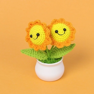 Handmade crochet smiling sunflower potted plant ornament with dual blossoms on orange background