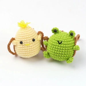 Close-up of handmade crochet frog and chick car charms with high-quality cotton yarn texture