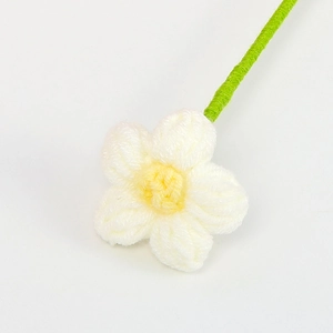 Fiore fatto a mano all'uncinetto con petali bianchi, cuore giallo e stelo verde su bianco