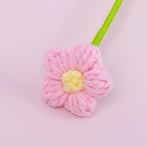 Fiore di puff rosa fatto a mano all'uncinetto con centro giallo e gambo verde