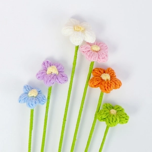 Dettaglio di sei fiori a sbuffo fatti a mano all'uncinetto con trama in lana colorata
