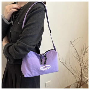 Detail of lavender nylon shoulder bag with FANYISSA logo and dual zippers on a model