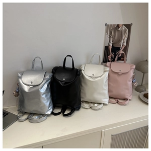Dettaglio di quattro zaini colorati in pelle PU con fibbie in metallo e graziosi ciondoli
