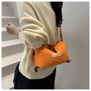 Detail of orange nylon shoulder bag with FANYISSA logo and black drawstring fastener