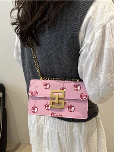 Pink lychee leather crossbody bag with red cherry prints and golden chain strap