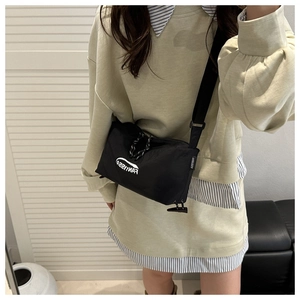 Detail of waterproof nylon crossbody bag with brand logo and woven zipper pull cord