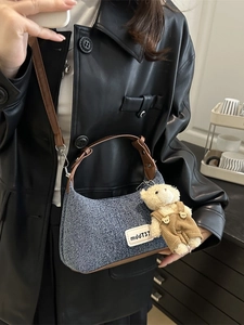 Retro denim dumpling shoulder bag with brown leather trim and a cute plush bear charm