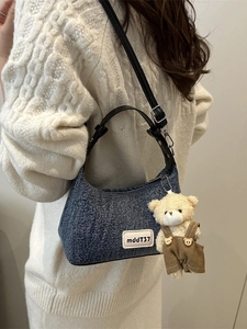 Retro denim blue hobo bag with a plush bear charm and adjustable leather shoulder strap