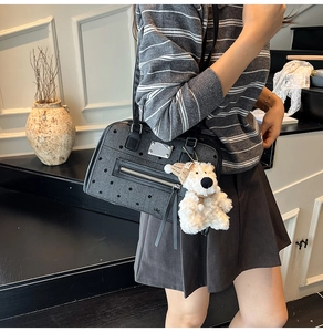 Detail of grey polka dot canvas bag with zipper pocket and cute bear plush charm