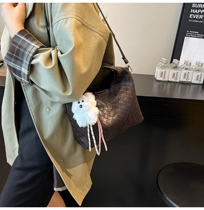 Detailed view of dark brown woven checkerboard texture on a vintage hobo shoulder bag