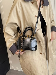 Classic black shell bag with glossy finish and gold hardware shown on model