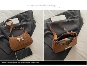 Detailed view of leopard print crossbody bag showing spacious interior and butterfly charm