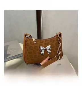 Detail view of brown leopard print handbag with silver butterfly buckle and chain strap