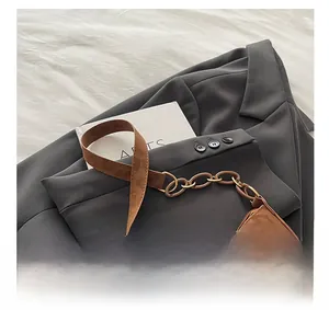Detail of leopard print crescent bag featuring silver metal bow and resin chain strap