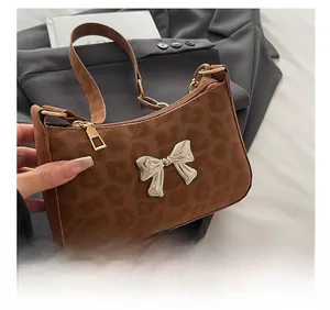 Close-up of brown leopard print crossbody bag with silver butterfly metal buckle