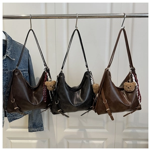 Detailed comparison of brown and black leather tote bags with cute bear pendants
