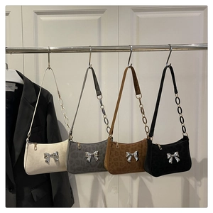 Detailed view of women's underarm bags with suede textures and silver butterfly accents