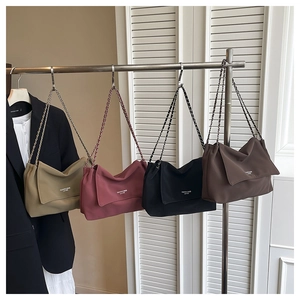 Détail de quatre sacs cabas à chaîne polyvalents en coloris kaki, rose, noir et marron foncé
