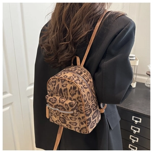 Detail view of mini leopard print backpack with brown straps and zipper pockets for women