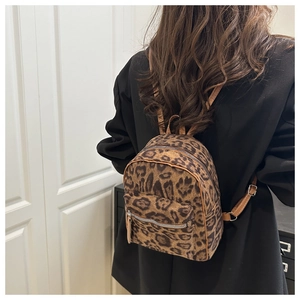 Detail shot of mini leopard print backpack with plush texture and brown leather straps