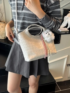 Chic cream woven leather handbag for women with plush charm and adjustable strap