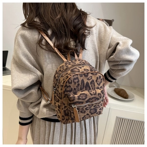 Close-up of stylish leopard print mini backpack with brown faux leather straps