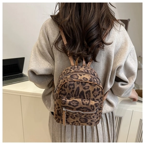 Detailed view of mini leopard print backpack featuring faux fur texture and zipper pocket