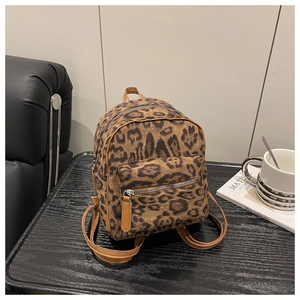 Detailed macro view of leopard print mini backpack with soft suede texture and leather straps