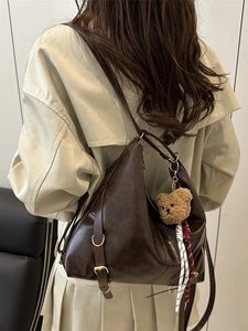 Retro brown PU leather tote bag with a plush bear charm and adjustable side strap detail
