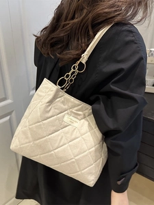 Chic cream quilted tote bag with diamond stitching and golden chain shoulder strap