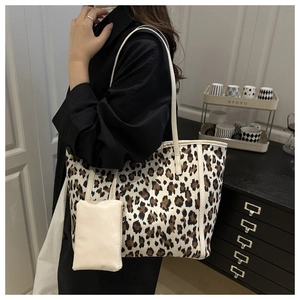 Detailed view of large leopard print tote bag with a cream-colored mini zipper pouch