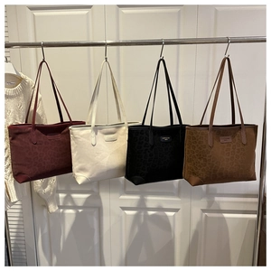 Detail view of large tote bags in burgundy, cream, black and brown with leopard texture