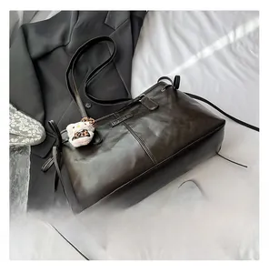 Detail of dark brown vintage faux leather tote bag with natural grain and bow tie decor