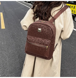 Detail of vintage leopard print backpack with gold hardware and brown nylon straps