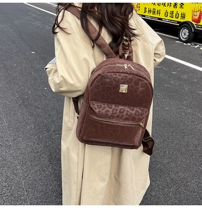Outdoor shot of the large leopard print backpack with gold zipper and metal plate detail