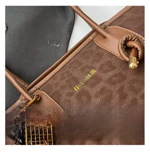 Détail du sac léopard marron en cuir lisse avec un pendentif raquette de tennis doré