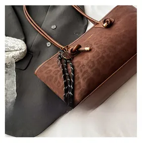 Gros plan détaillé du sac cabas marron en daim léopard avec bandoulière à nœuds élégante