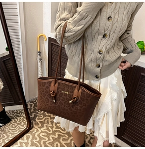 Détail du sac sous le bras à imprimé léopard avec logo doré sur cuir synthétique chic