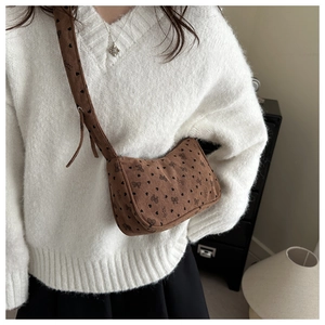 Detail of brown corduroy hobo bag with black heart prints and wide shoulder strap