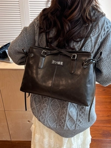 Retro black PU leather backpack with drawstring bow detail and brand logo for women
