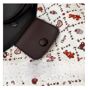 Detail view of a vintage dark brown faux leather pouch with a magnetic snap closure