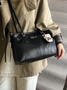 Vintage black PU leather multi-functional backpack with plush pendant worn by model