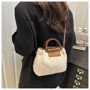 Detail der flauschigen cremefarbenen Plüschtasche mit Holzgriff und abnehmbarem Gurt